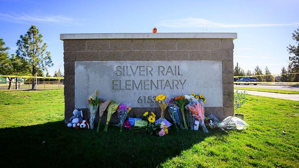 Flowers lay against the entry sign of Silver Rail Elementary School on October 16, 2026 in Bend, Oregon.
